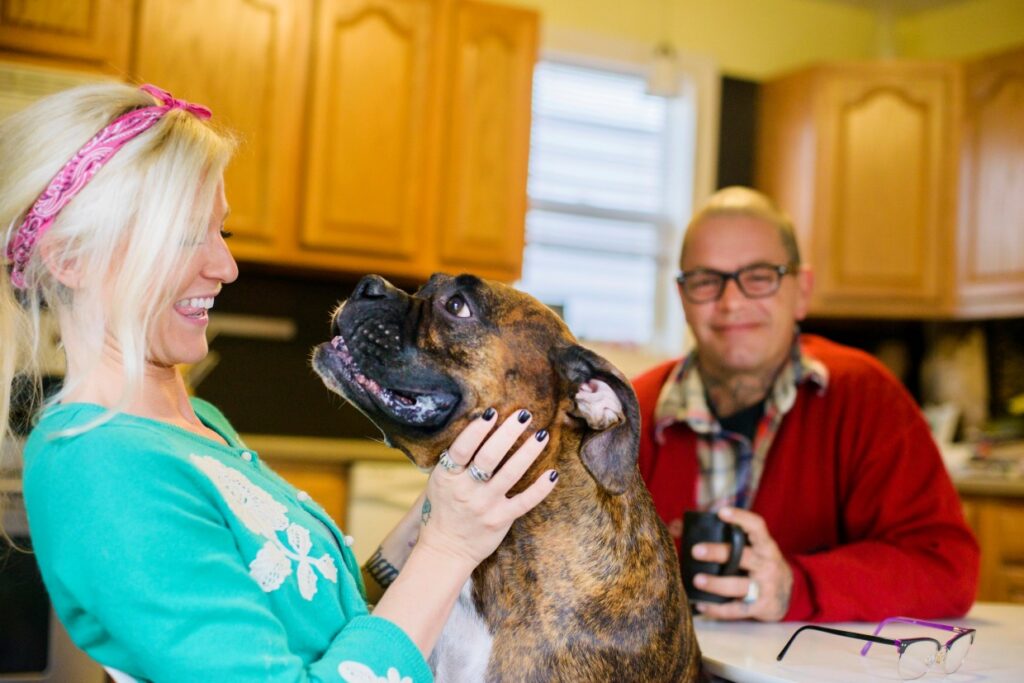 Woman holding a small dog at a kitchen counter during an in-home veterinary visit in Scottsdale, AZ