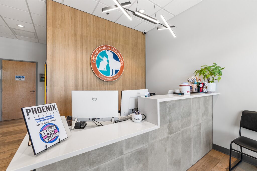 Front desk and Phoenix Mobile Veterinarians wall logo inside the Scottsdale veterinary hospital